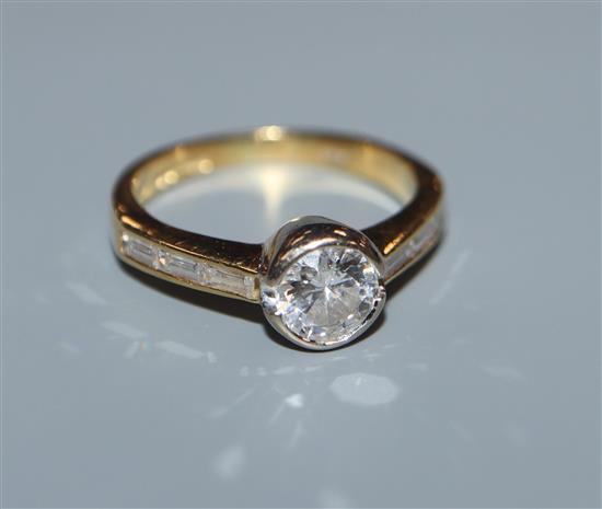 A modern 18ct gold and collet set single stone diamond ring, with baguette cut diamond set shoulders, size H.